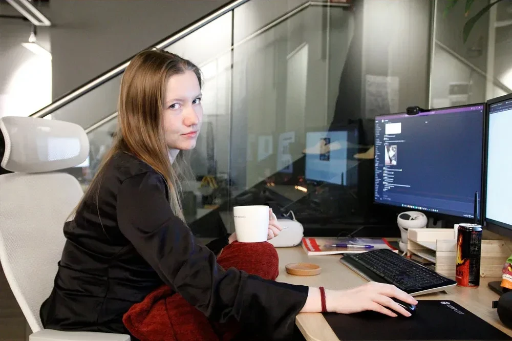 employee working at her desk with a blanket and tea